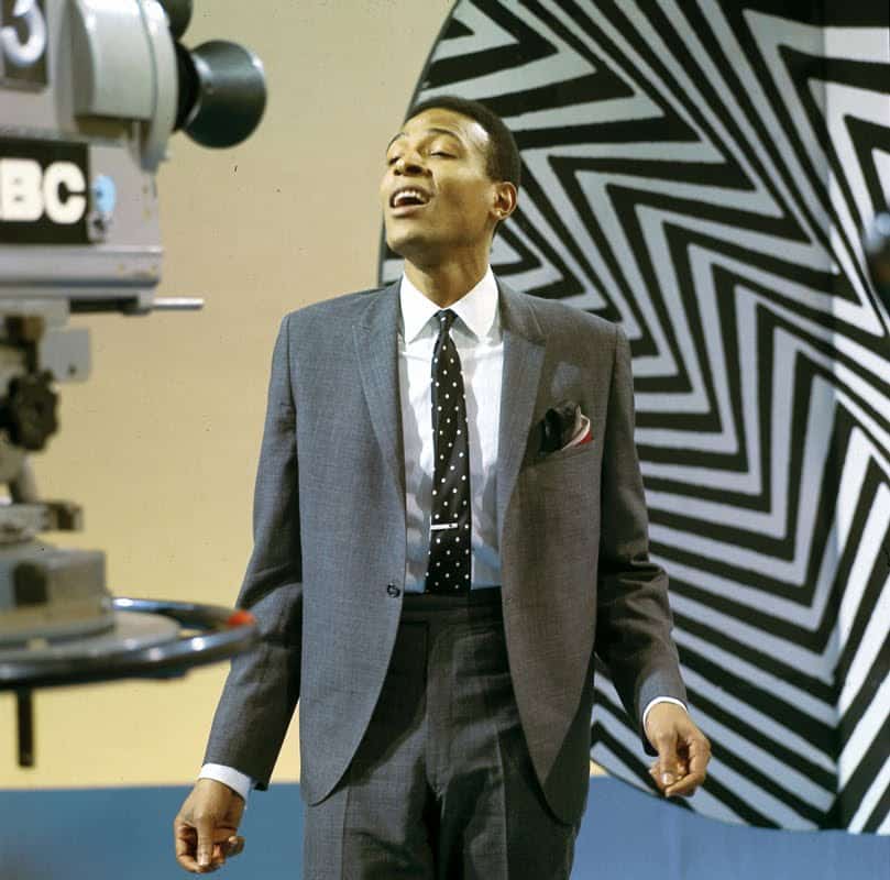 Marvin Gaye en costume gris et cravate sur un plateau de télévision