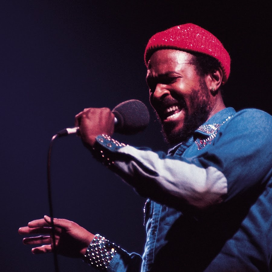 Marvin Gaye chantant sur scène en chemise bleue avec un bonnet rouge