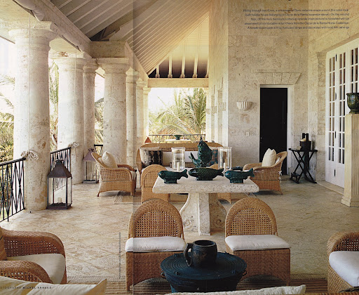 Terrasse en pierre de la maison de Punta Cana avec table dressée et fauteuils en rotin