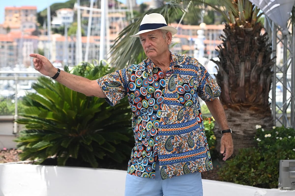 Bill Murray à Cannes en chemise imprimée, short bleu clair et chapeau blanc.